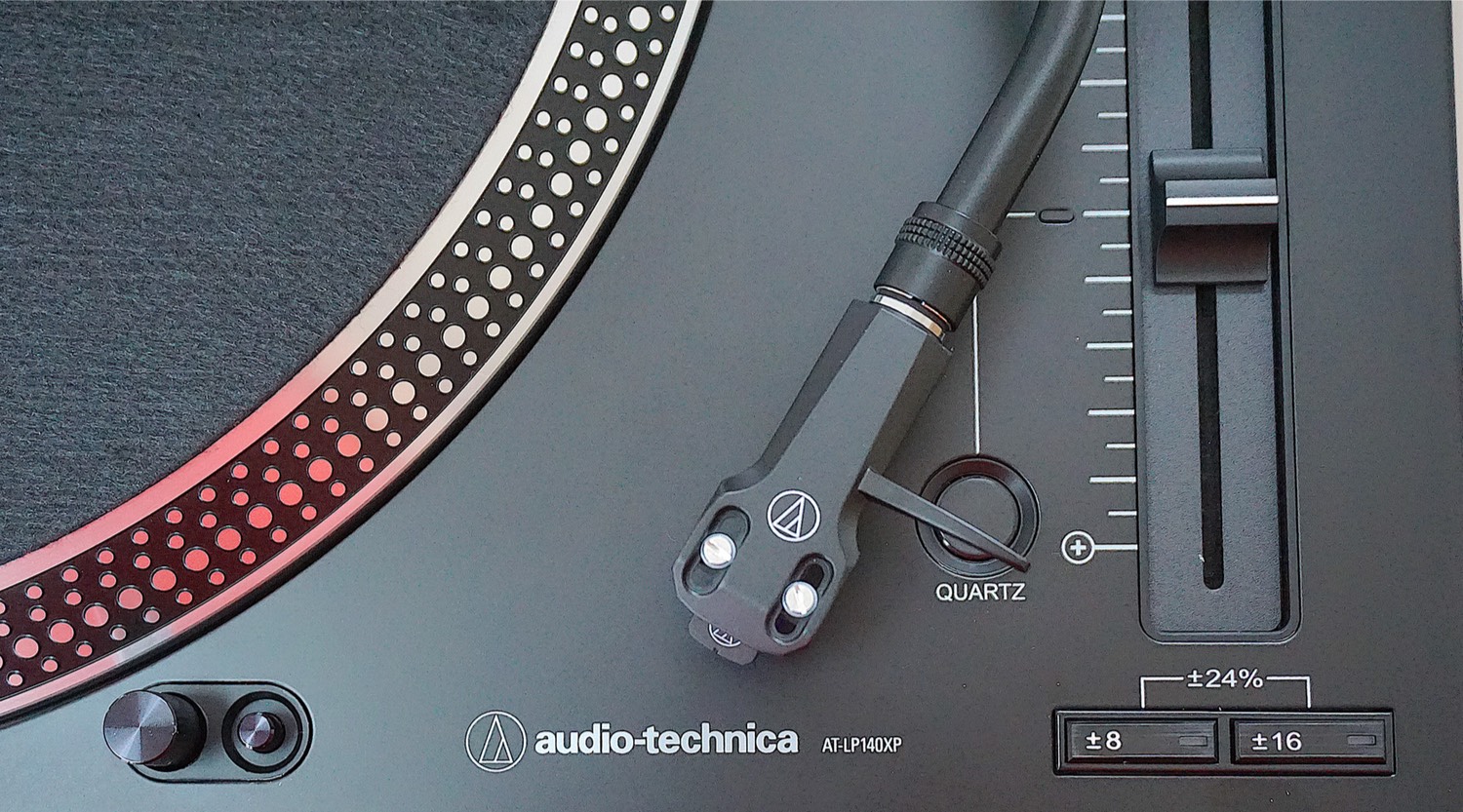A detailed view of the Audio-Technica AT-LP140XP turntable’s pitch control slider and stroboscopic platter.